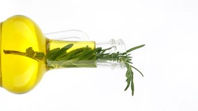 rotating olive oil in bottle with sprig of rosemary, white background. vertical video