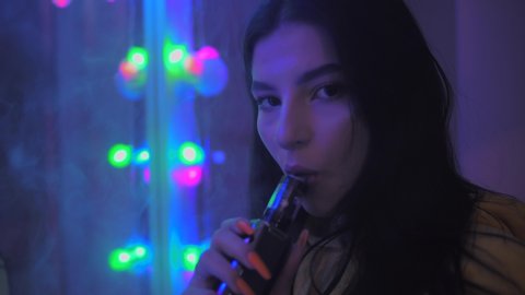Young girl smoking vape, mirror, vaping, night concept, close up