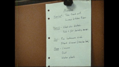 1970s: List of chores on fridge. Children walk through door, take off coats. Girl opens fridge, hands apple to boy. Children look at list of chores.