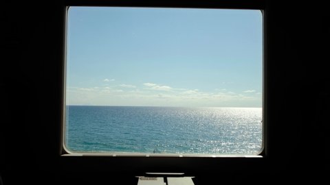 Travelling by Train along the sea coast in Italy. Look out from the train window at empty beach and Mediterranean Sea at summer. 