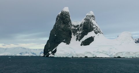 WS Lemaire Channel with snow covered rocks at sunset / Antarctica