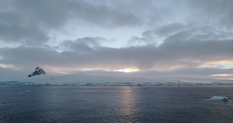 WS Clouds over channel and snow covered coast of Damoy Point at sunrise / Antarctic Peninsula, Antarctica