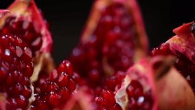 Pomegranate fruit. Fresh and ripe Pomegranates rotating over black Background. Organic Bio fruits close-up. Diet, dieting concept. Vegan food. Slow motion 4K UHD video
