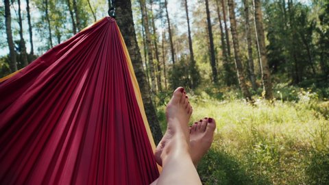 Relaxing on a hammock by the edge of the forest - mid shot