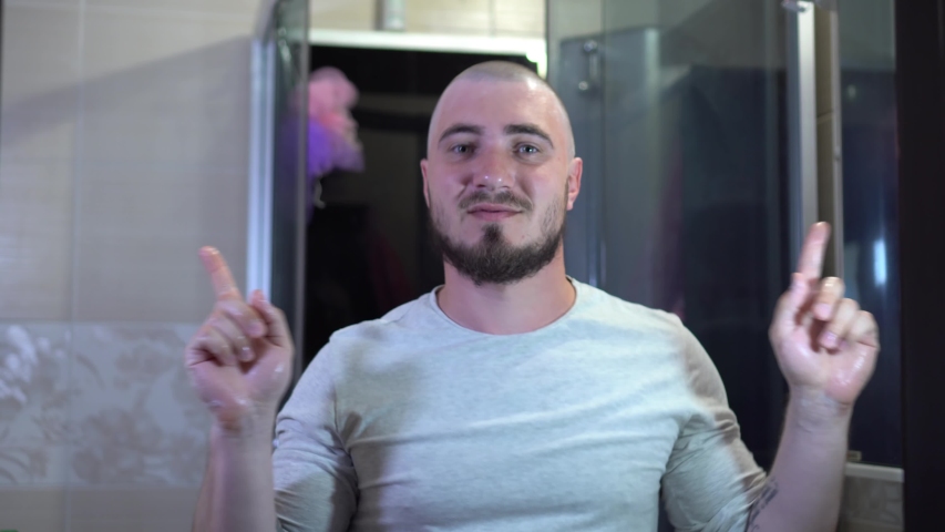 Cool Young Man with a Beard Funny Dancing as a Metrosexual in the Bathroom of His House. The concept of Happiness and Positive.