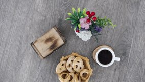 Coffee cup with sweets and wooden box on wooden table background.