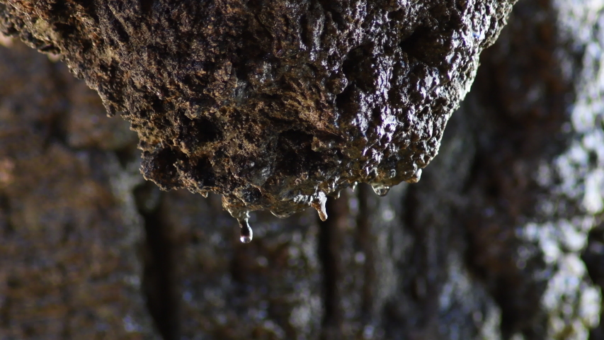 Water drops sliding through a rock in a cave Royalty-Free Stock Footage #1055502770