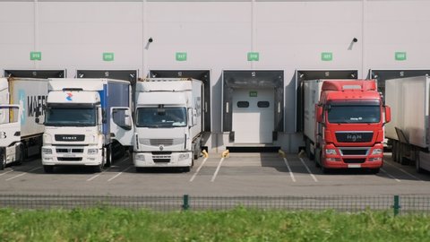 Trucks in logistics warehouse do unloading or loading of cargo. Domodedovo, Russia - June 10, 2020.