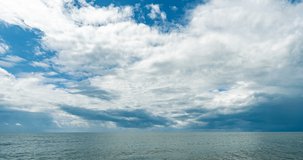 4k time lapse of the sea and blue sky, white clouds evolve and change shape, dynamic weather, beautiful seascape, video loop