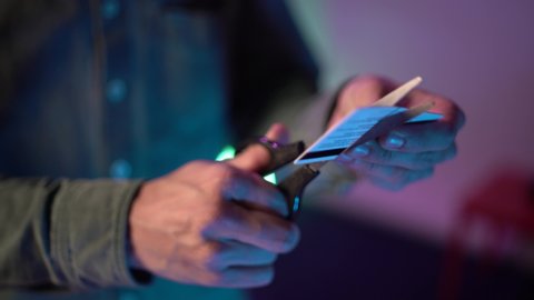Close up shot. Man hands cuts up his credit card.