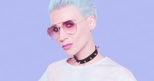 Fashion Aesthetic alternative Model with blue short hair, stylish choker and sunglasses posing in studio against blue background. Fashion emotions,  hairstyle and accessories concept