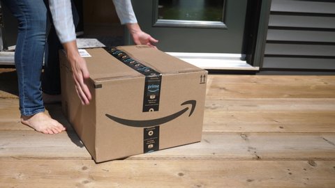 Haliburton, Canada on July 1st: Woman picks up Amazon Prime package on July 1st, 2020 in Haliburton, Ontario, Canada. Amazon Prime is a subscription service giving customers quicker delivery times.