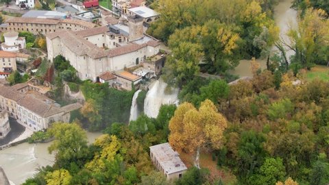 Circle flight and view of Castello Boncompagni-Viscogliosiand, fortified palace, near two waterfalls, Lazio, Italy, circle aerial