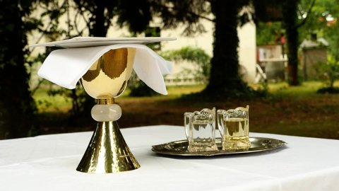 golden chalice together with water and wine on a table, prepared for a service