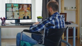 Disabled businessman in wheelchair during a video call from home office.