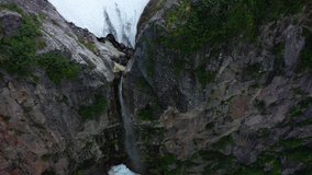 Waterfall hidden in high rocks in the side of volcano Viluchinskiy, Kamchatka peninsula, 4k video