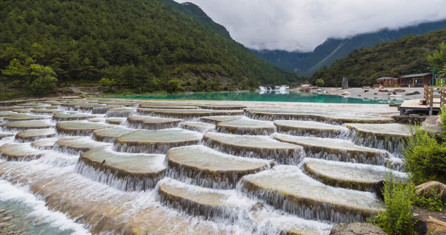 4K, 10bit, YUV422 timelapse of Lanyuegu waterfall or Blue moon valley landscape with Jade Dragon Yulong snow mountain background, Lijiang, Yunnan, China