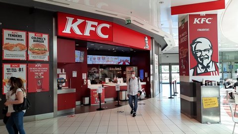 Pompei, Italy. June 18th, 2020. La Caertiera Shopping Mall. Some people wearing a safe protective mask walk past a KFC store in a mall.