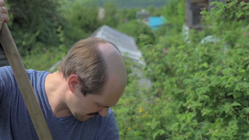 countryside, woman neighbor in a swimsuit walks past a man in a garden.