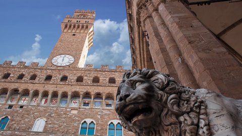Timelapse of old Palace ( Palazzo vecchio) in Florence ( Firenze ) from the square. Close up of a lion statue and clouds in the sky in background