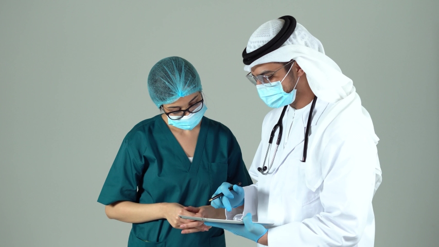 Arab doctor and nurse assistant discussing symptoms of patient with use of digital tablet computer collaborating. Hospitals. Cooperation.