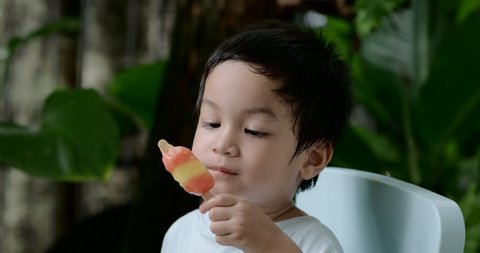 3 years old Asian little boy having Popsicle sticks.
