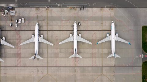 Wroclaw, Poland - June 17, 2020: Aerial flat lay, top down view of airplanes parked on airport apron in front of modern airport in Wroclaw. Dolly out camera shot from drone