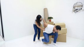 Man has lower back pain injury from heavy lifting during removal into new flat, his wife tries to help him.