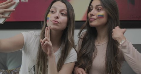 Two Beautiful Colombian Women Taking Selfies With A Smartphone In The Living Room - Slow Motion