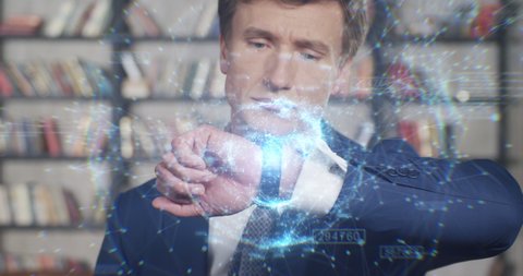 Businessman Looking at His Smart Watch with Futuristic Digital Hologram Turning in Slow Motion. Innovations in Mobile Devices for Business, Technology Concept. Businessman Series 4K UHD 4096x2160. Video de stock