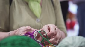 Close-up of woman weaving net of ropes. Art. Old women's hands masterfully tie knots and weave colored ropes into net. Creative fair with handmade items and decorations - Powered by Shutterstock - Get 15% off with code: PIKWIZARD15