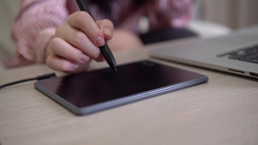Graphic designer using laptop, tablet and pencil, hand close up, painting illustartion, freelancer