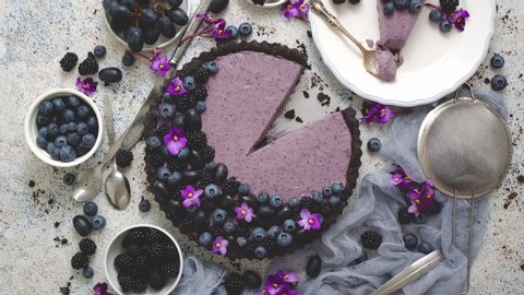Plate with homemade piece of delicious blueberry, blackberry and grape pie or tart served on table. Top view, flat lay.