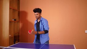 young men playing and enjoying table tennis in club house