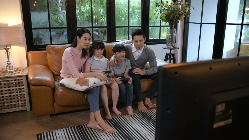 Family concept. Parents and children playing games in the living room. 4k Resolution.