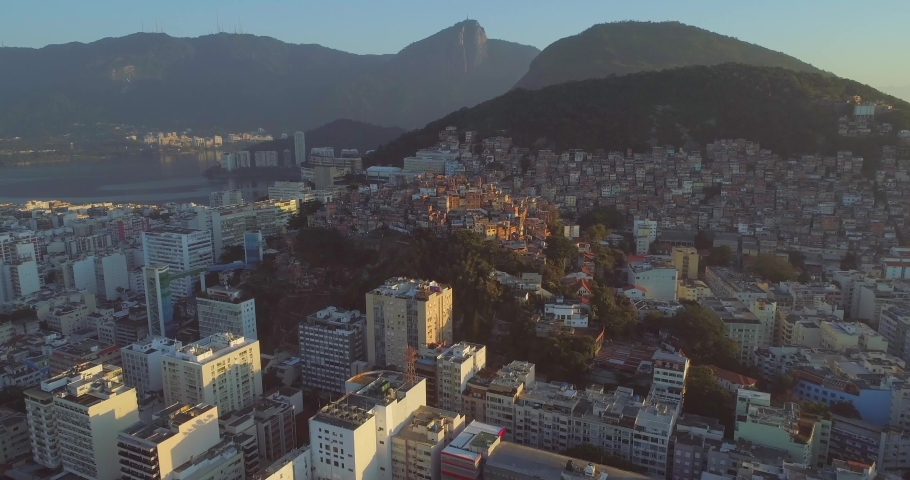 Aerial move towards Cantagalo hilltop favela set amongst luxury apartment buildings and Rio de Janeiro's natural mountains Royalty-Free Stock Footage #1055645276
