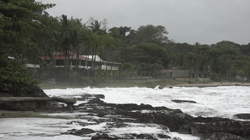 Coast of Limon City in Costa Rica. Wild Sea with a cloudy sky. Beautiful houses facing the sea. Very stormy day.