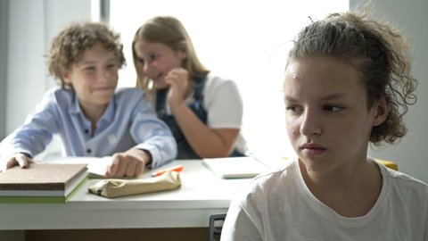 Two teens scoff at their defenseless classmate. Child cruelty. School bullying.