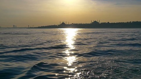 Glittering sea of Bosphorus just in time for sunset. Slow Motion. Hagia Sophia and Blue Mosque in the distance. Istanbul, Turkey. SM
