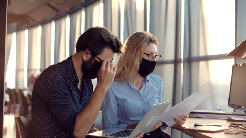 Coworkers Working Together In Lockdown Avoid Self Distance. Employees Cooperating In Working Together On Workplace.Two Colleagues Talking In Face Mask Office On Covid19 Coronavirus Pandemic Quarantine Royalty-Free Stock Footage #1055669711