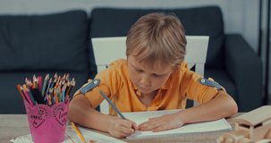 adorable boy drawing with color pencil at home