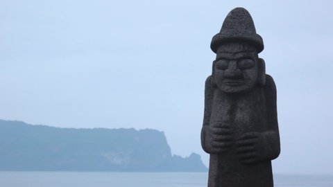 Jeju, South Korea - May 2017 : Stone Grandfather(dol hareubang) and beautiful sea scenery - Jeju Island, South Korea.