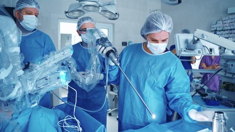 KYIV, UKRAINE - May 2020: Medical operation involving robot. Specialist puts the robotic device into a medical machine in the operating room. Robotic surgery.
