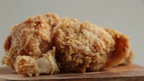 Close up fried chicken on spinning wood cutting board.