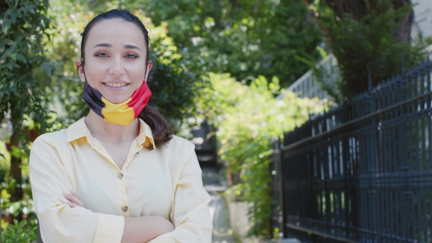 Portrait of female with medical mask with Belgium flag. Everything is OK sign.