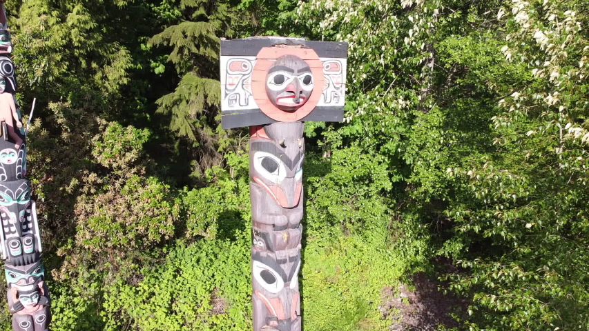 Total Poles First Nations Art in Stanley Park - Chief Skedans Mortuary Pole - drone view - flying away