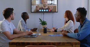 Multi-ethnic group of male and female creative business colleagues at a meeting, talking with business partners online during a video conference call. Business technology communication.