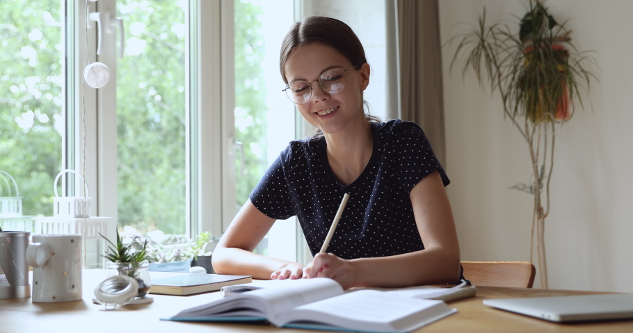 Student teenager wear eyeglasses sit at table at home learning school university subject, language practise, do task preparing for exams, reads chapter makes important notes, studying process concept Royalty-Free Stock Footage #1055702756