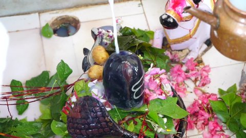 Sikar, Rajasthan, India - July 08, 2020 - Shiva linga puja, Offering water on the Shivling