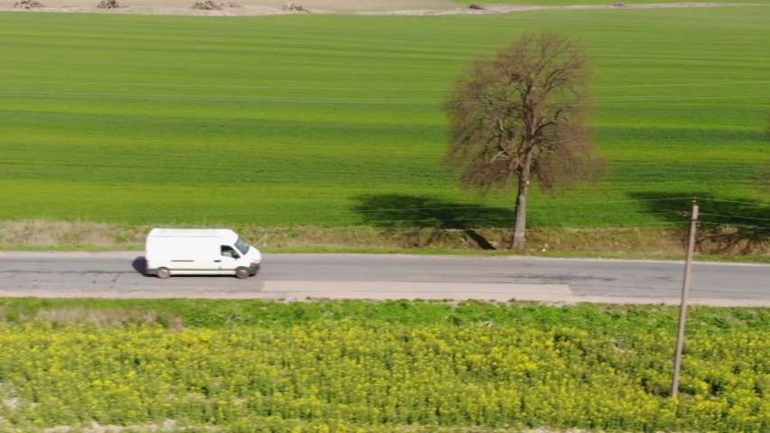 Delivery Van. Postal Delivery Service. Aerial View Shot of Car riding Through Empty Rural Road. Road on Countryside. Truck Driving Through Beautiful Suburban. Aerial View Spring Agricultural Fields. | Shutterstock HD Video #1055707238